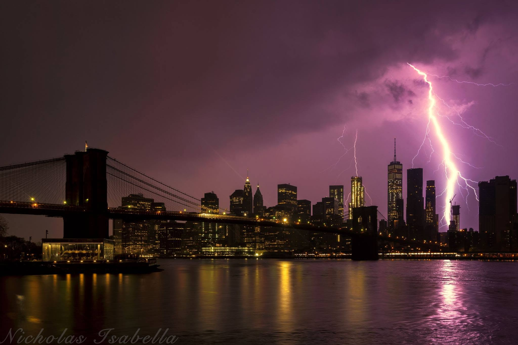 Lightning illuminating the New York City skyline and Brooklyn Bridge at night